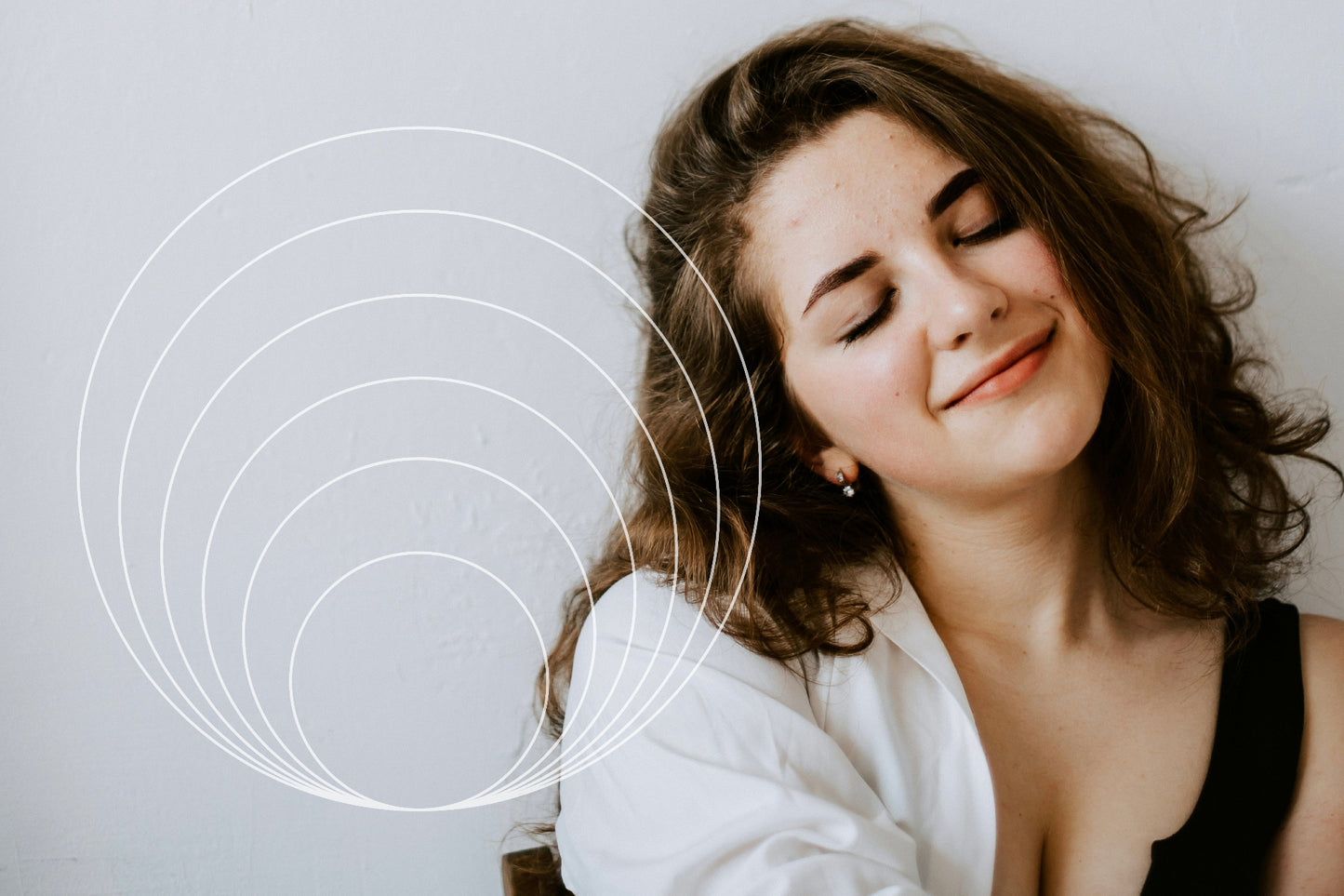 Woman with closed eyes and a soft smile, with concentric circles overlayed on the left side.